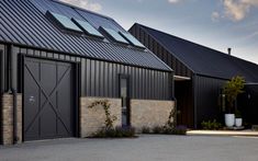 two black garage doors are open on the side of a building