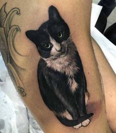 a black and white cat tattoo on the leg