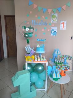 a table with balloons, cake and decorations on it