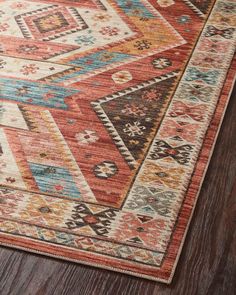 an orange and blue area rug with multicolored geometric designs on the bottom half