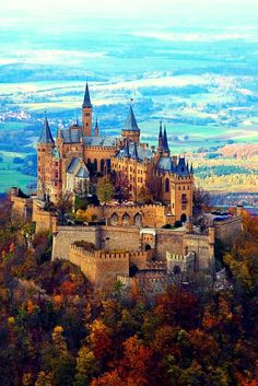 an old castle on top of a hill surrounded by trees