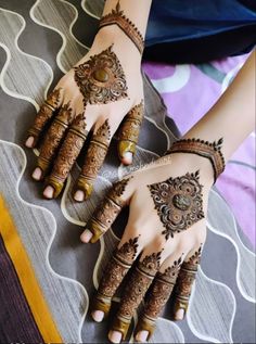 two hands with henna tattoos on them