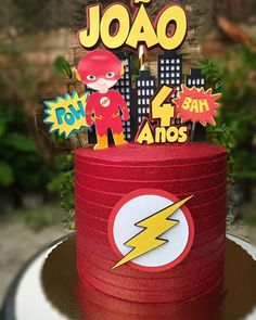 a birthday cake decorated with the flash logo and superhero stickers on it's top