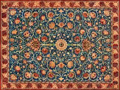 an antique rug with flowers and vines in blue, red, yellow and orange colors