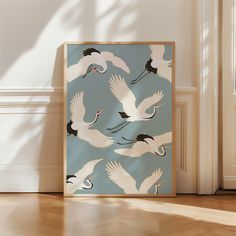 there are many white birds flying in the air on this blue wallpapered room