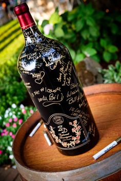 a bottle of wine sitting on top of a wooden barrel