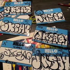 four blue and white license plates sitting on top of a wooden table covered in graffiti