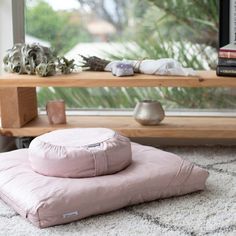 a pink pillow sitting on top of a white rug