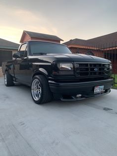 a black truck parked in front of a house