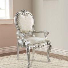 a white chair sitting on top of a wooden floor next to a window in a room