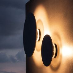 a light that is on the side of a building with clouds in the back ground