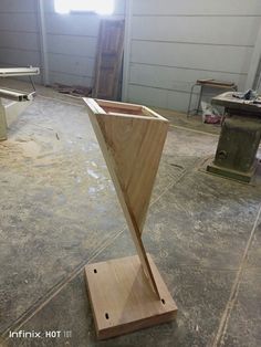 a piece of wood sitting on top of a wooden stand in a room filled with tools