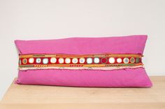 a pink pillow sitting on top of a wooden table