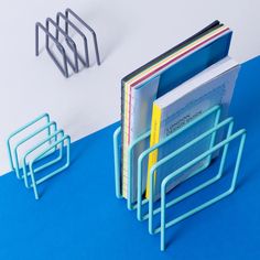 a stack of books sitting on top of a blue floor next to a metal rack