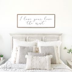 a bed with white sheets and pillows in a bedroom next to a wall mounted above it