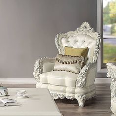 a living room with a white chair and coffee table in front of a large window