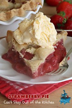 a piece of strawberry pie with ice cream on top and strawberries in the background