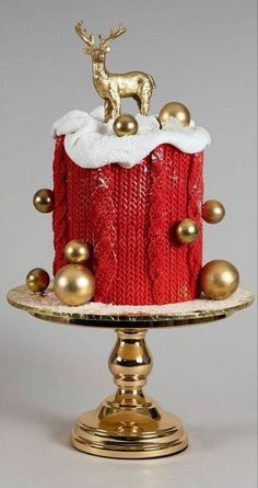 a christmas cake decorated with gold balls and a red sweater