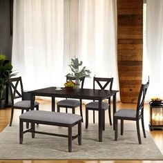 a dining room table with four chairs and a bench