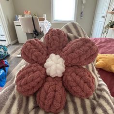 a stuffed flower on top of a bed