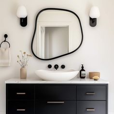 a white sink sitting under a large mirror