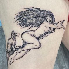 a woman with long hair and a cat sitting on her leg is depicted in this tattoo design