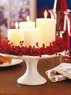 candles are lit on a cake plate with red flowers