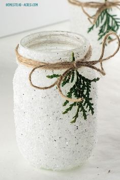 two mason jars decorated with twine and pine needles