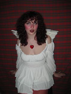 a woman dressed in white posing for the camera with her hands on her hips and red lips