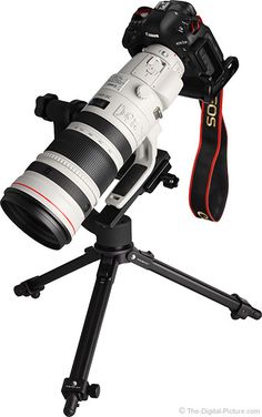 a camera sitting on top of a tripod with a lens attached to it's body