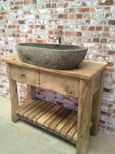 a sink made out of wooden pallets in front of a brick wall and floor