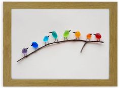 a group of birds sitting on top of a branch in front of a white wall