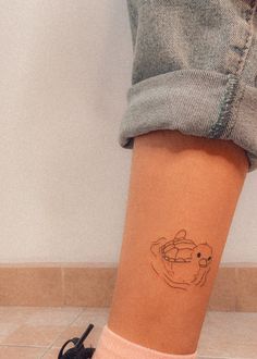 a woman's legs with a small tattoo on her left leg and an animal drawn on the side