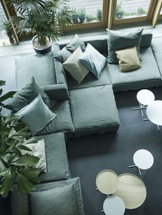 an overhead view of a living room with couches, tables and plants in it