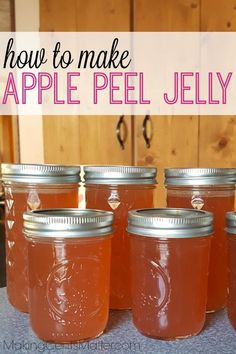 four jars filled with apple jelly sitting on top of a counter