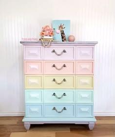 an old dresser is painted in pastel colors