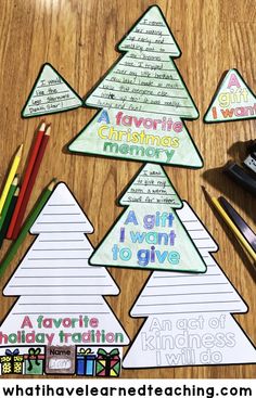 four christmas tree shaped cards with pencils and crayon markers on the table