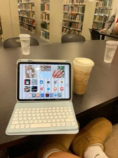 an open laptop computer sitting on top of a table next to a cup of coffee