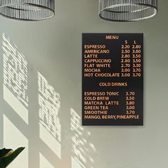 a menu hanging on the side of a wall next to two potted planters