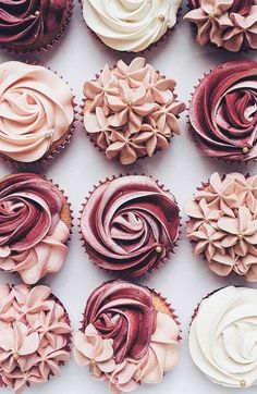 cupcakes decorated with pink and white frosting on top of each other in rows