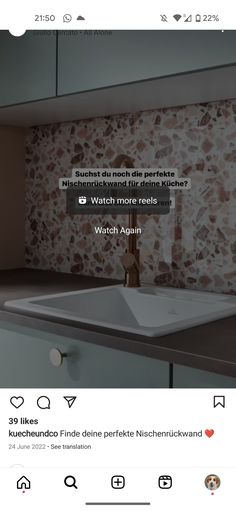 a bathroom sink sitting under a mirror next to a wall mounted faucet in a bathroom