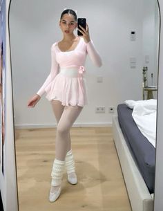 a woman in a ballet outfit taking a selfie