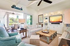 a living room filled with furniture and a flat screen tv mounted to the side of a wall