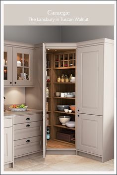 an open cabinet in the middle of a kitchen with lots of cupboards and drawers