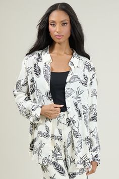 Nothing completes the look, like Another Day In Paradise Tropical Print Oversized Button Down Shirt! It features a classic collar with functional buttons along the center front. Maintains an oversized fit with a slight drop shoulder and elongated hem. Layer it over a ribbed tank and the matching pants! - Functional buttons- Button cuffs- Oversized- Drop shoulder- Color: White BlackSize + Fit - Model is 5'8" and wearing size XS- Measurements taken from size S - Chest: 24"- Length: 30" Fabric Self Effortless White Button-up Blouse, White Camp Collar Shirt For Loungewear, Oversized Loungewear Blouse With Button Closure, Oversized Blouse For Loungewear With Button Closure, Oversized White Blouse With Button Closure, White Button-up Top For Loungewear, Chic White Shirt For Loungewear, White Collared Shirt For Loungewear, White Button Closure Blouse For Loungewear