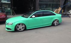 a green car parked in front of a building