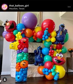 the balloon arch is decorated with sesame street characters and balloons that spell out the letter i