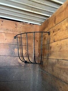 a wooden wall with a metal rack on it's side next to a door