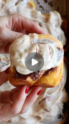 a person holding a doughnut with icing on it