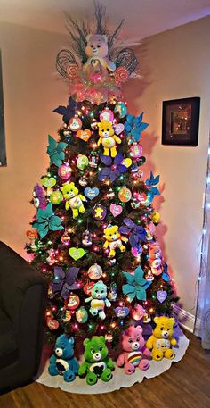 a brightly colored christmas tree with lots of little stuffed animals on it's top